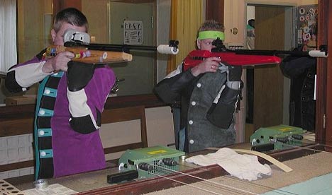 luftgewehrschuetzen Schießstand mit zwei Männern, die ein Luftgewehr bedienen